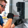 Electrician working at electric panel