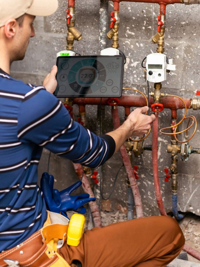 The technician checking the heating system with tablet in hand