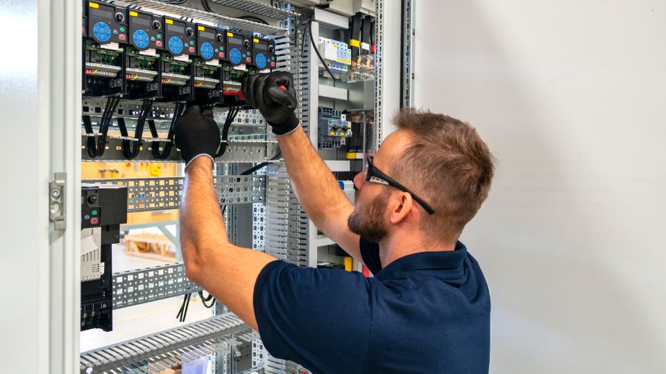 Electrician working at electric panel