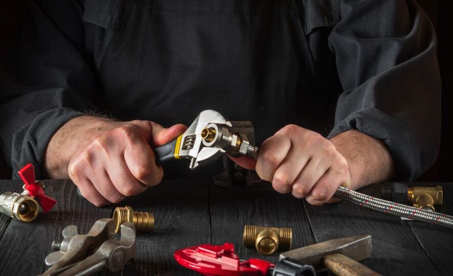 Plumber connects the brass fittings to the faucet with an adjust