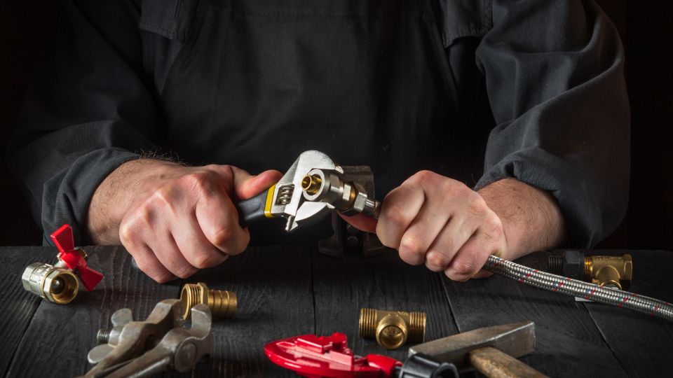 Plumber connects the brass fittings to the faucet with an adjust