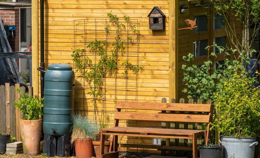 Rain barrel for rainwater harvesting and pot plants in the garden